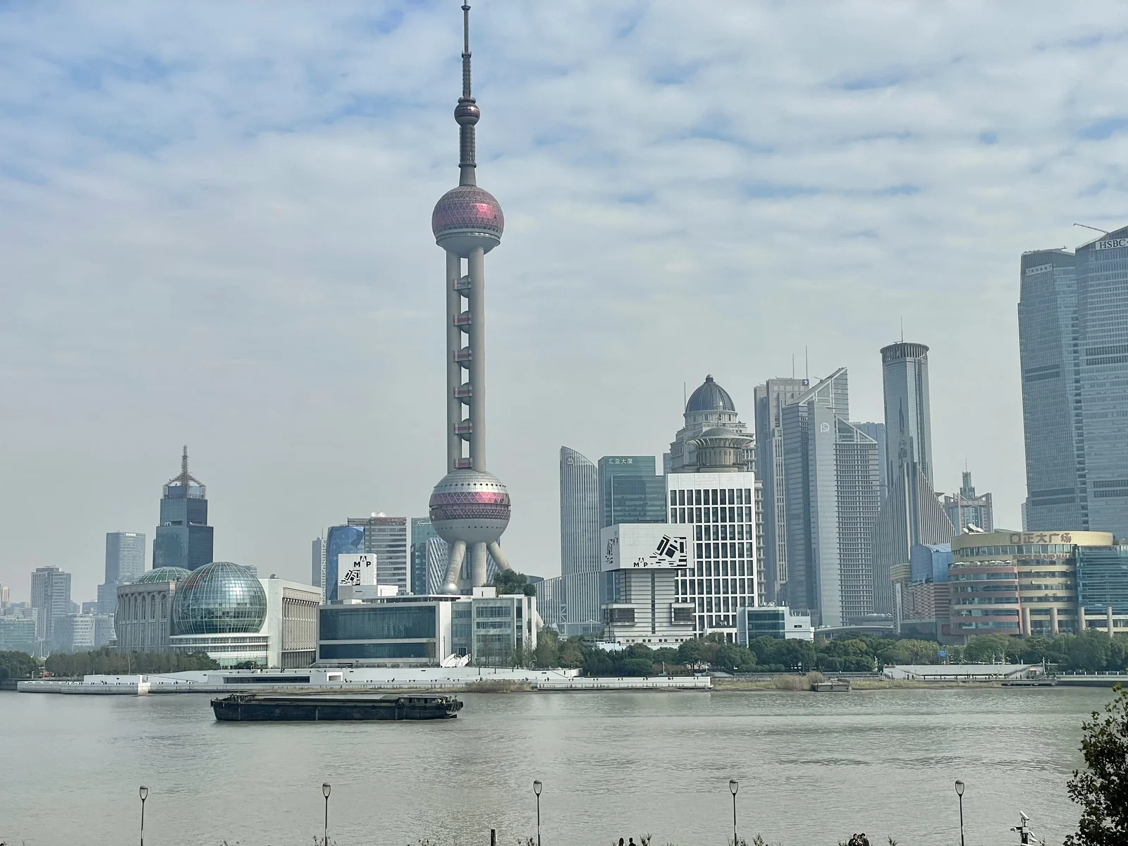 Museum of Art Pudong’s glazed frontage across the Huangpu River, below the Oriental Pearl Tower and Lujiazui buildings