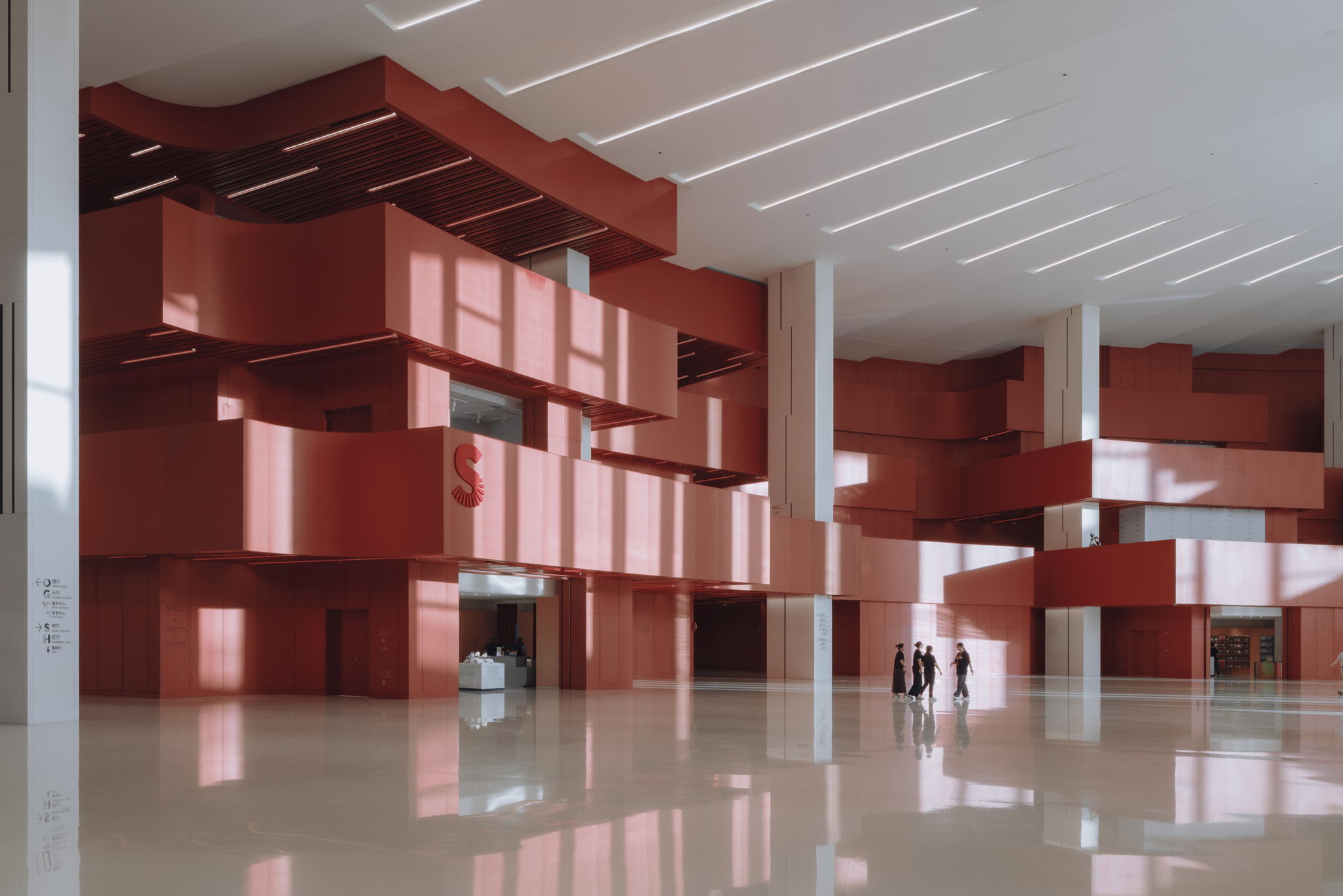 Daylight falling on the Grand Opera House’s red interior volumes and pale lobby floor