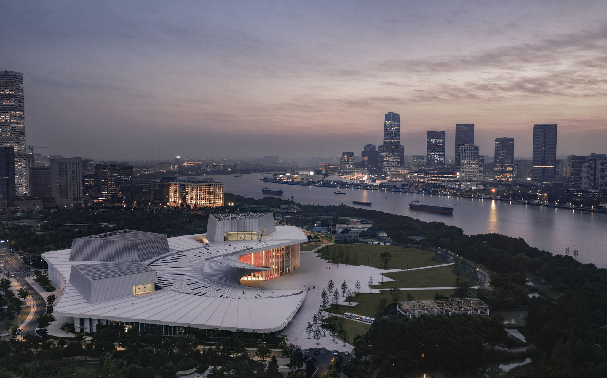 Shanghai Grand Opera House with its white pleated roof beside the Huangpu River at dusk