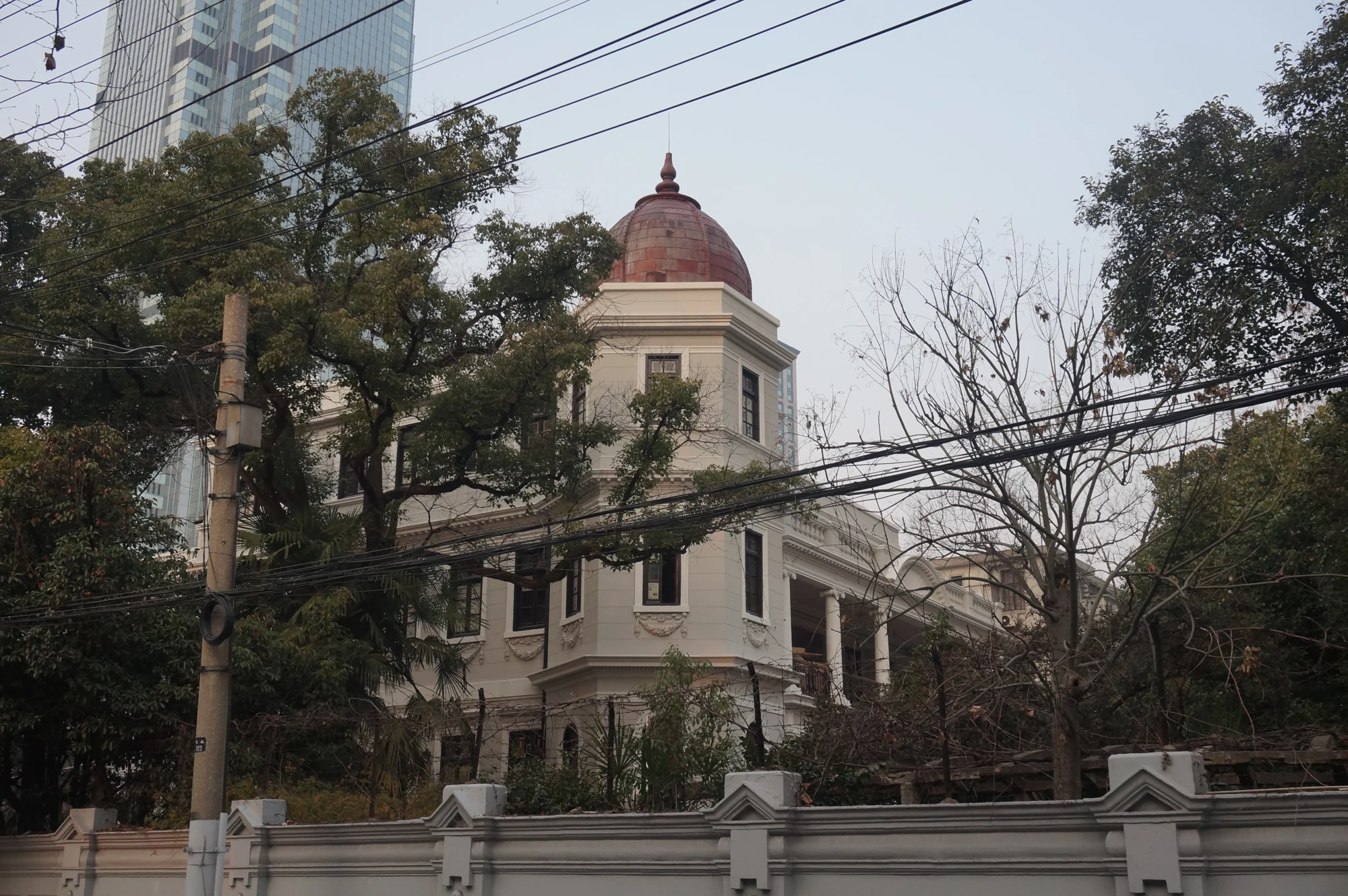 Archival 2015 view of Rong Zhai behind its garden wall and street cables, showing the pale facade and red domed tower.