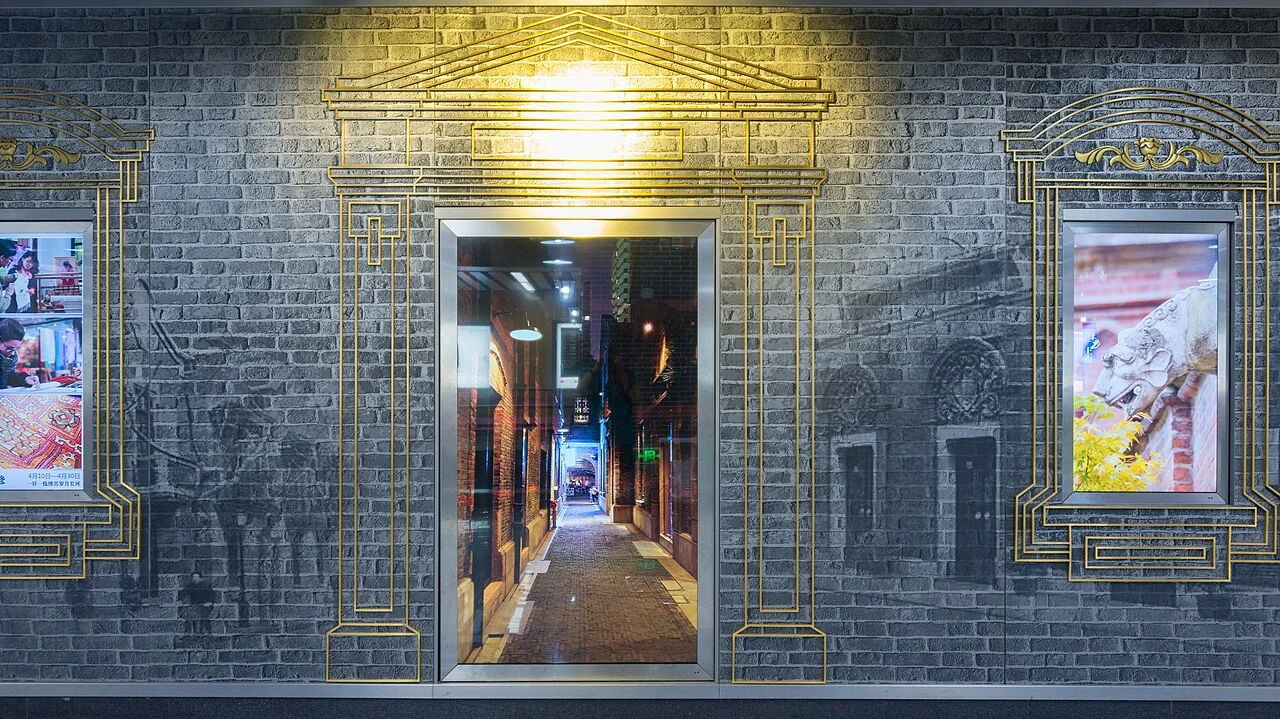 A stone doorway and grey brick facade illuminated at night in Xintiandi.