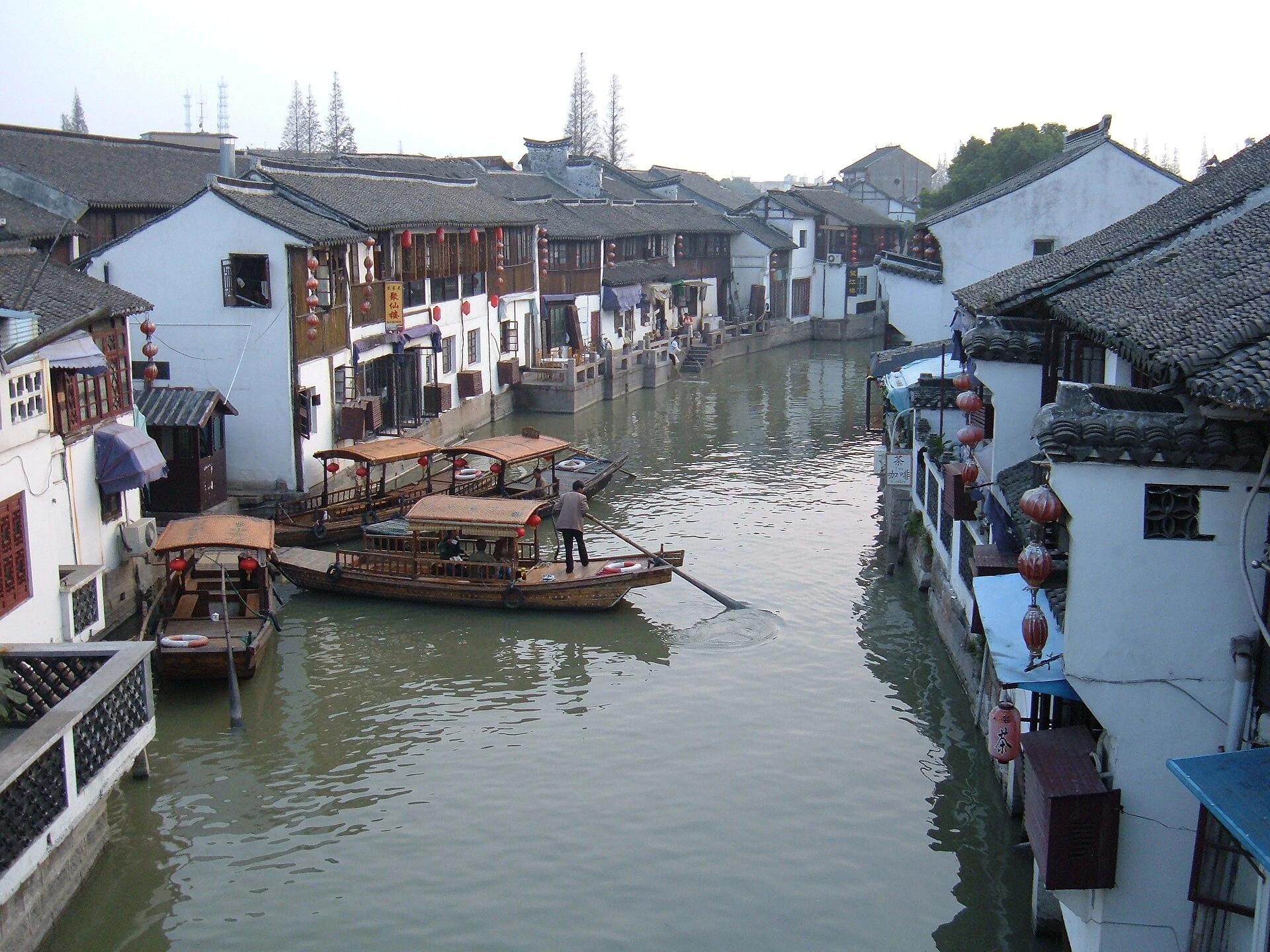 A canal, waterside houses and covered boats in Zhujiajiao