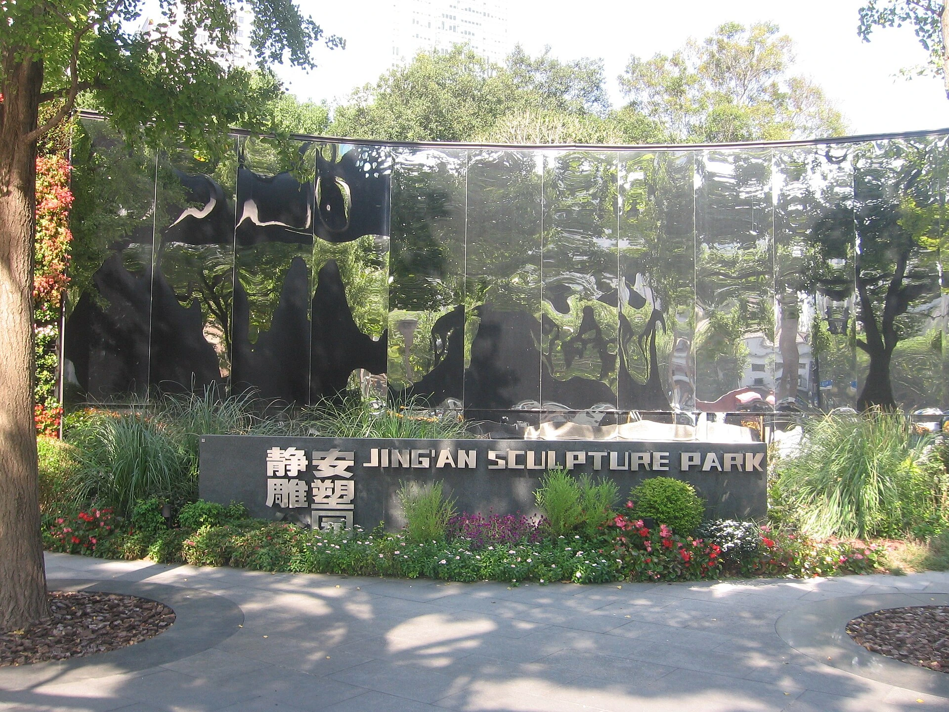 The Jing’an Sculpture Park name beside planting and a reflective entrance surface